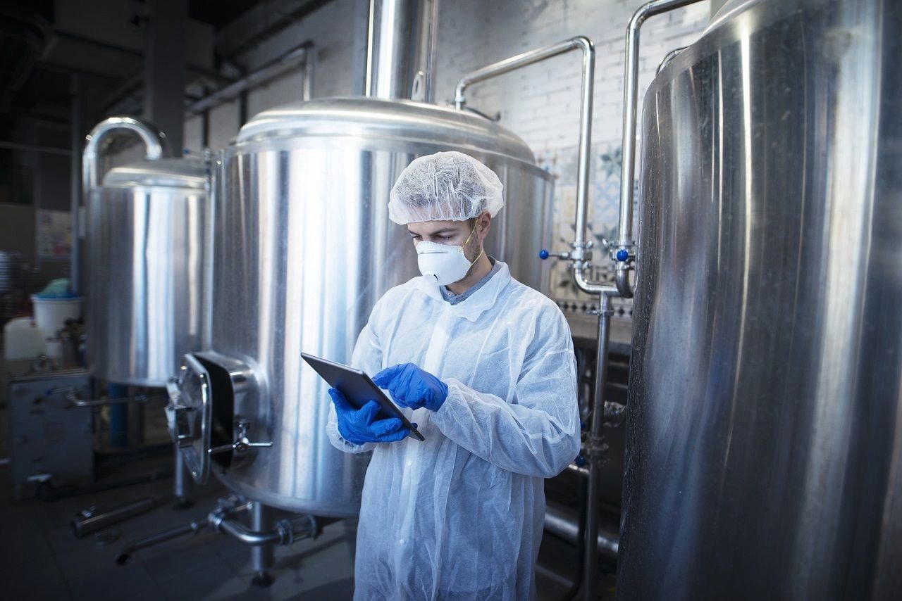 Trabajador con equipo de protección en planta de procesamiento de alimentos